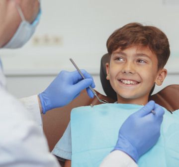 Dentist examining smiling child's teeth