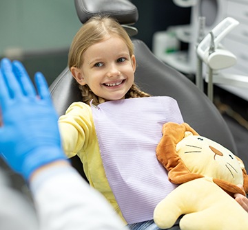 a child smiling while visiting her dentist