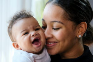 a parent holding their child and smiling